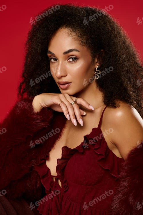 Preview: Trendy autumn fashion with a stylish woman and natural curls in a modern studio