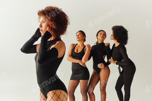 Preview: appealing sexy african american women in black stylish bodysuits posing together, fashion concept