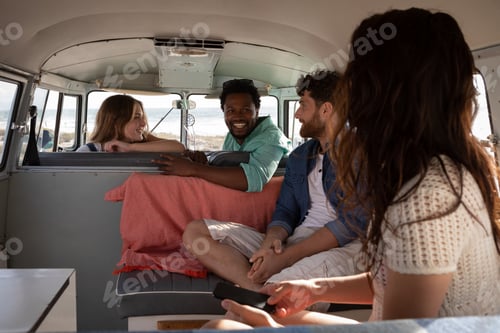 Preview: Group friends interacting with each others in camper van at beach