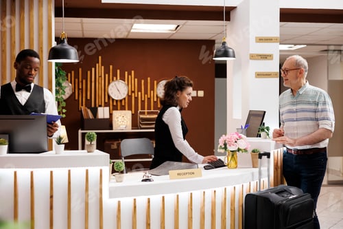 Preview: Friendly hotel check-in for elderly man