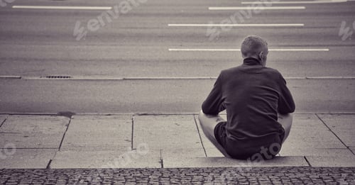 Preview: A toungbman seen from behind while sitting alone on stairs