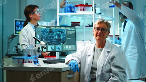 Preview: Portrait of old chemist woman with fatigued face in front of camera