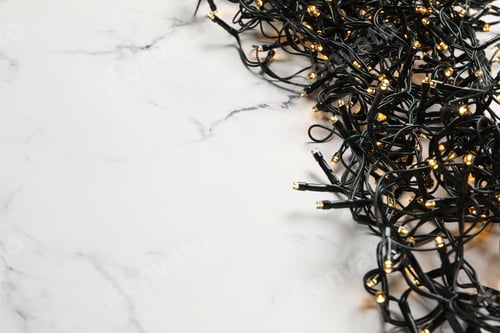 Preview: Garland with yellow lights on marble background, space for text