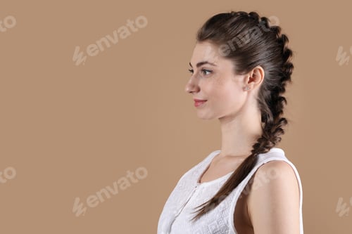 Preview: Woman with braided hair on light brown background. Space for text