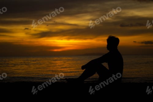Preview: Young adult male silhouette featured in a beach setting at sunset
