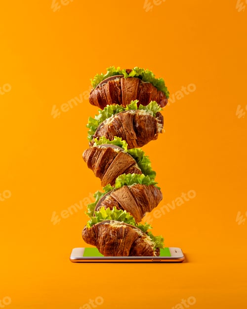 Preview: Croissants with filling and lettuce stack into tower emerging from smartphone screen