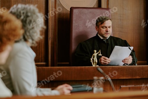 Preview: Middle Aged Caucasian Male Judge Reading Legal Documents during Court Hearing