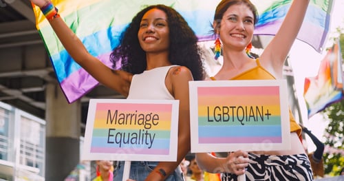 Preview: A lesbian couple waves a rainbow flag, a symbol of homosexuality, during a pride parade.