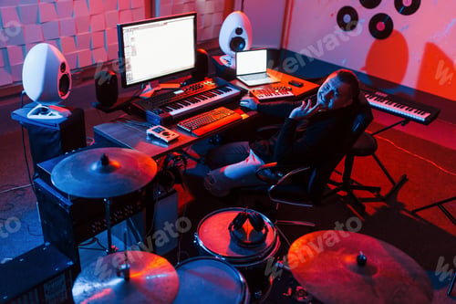 Preview: Sound engineer working and mixing music indoors in the studio near drum kit