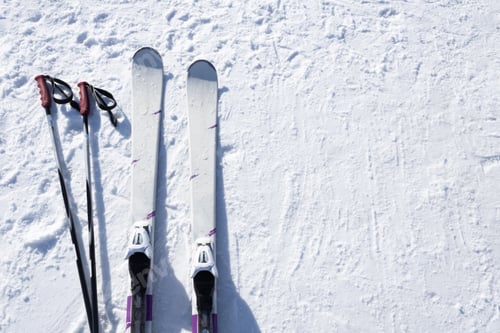 Preview: Mountain skis, sunscreen mask and ski sticks on bright alpine snow. Winter holidays. Extreme sport.