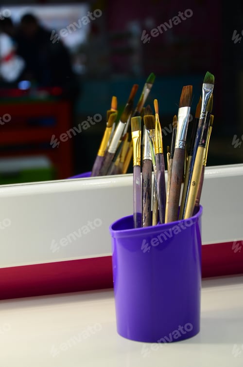 Preview: Art paint brushes in cup are located in the children's entertainment hall at the mirror