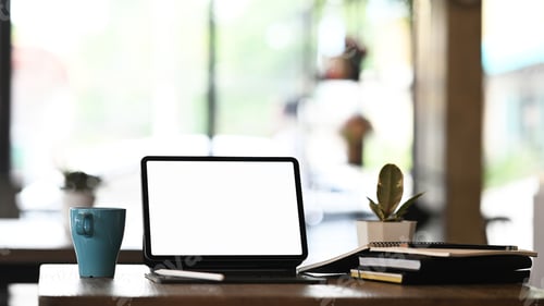 Preview: Simple workplace with blank screen computer tablet and office supplies on black wooden table.