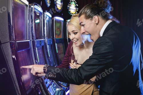 Preview: Young couple playing slot machines in the casino