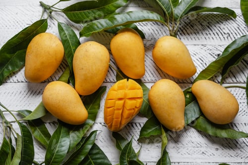 Preview: Ripe mangoes on white wood