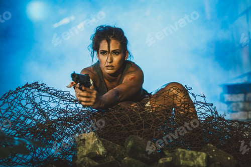 Preview: A Woman Standing on a Pile of Barbed Wire and Shooting With Gun