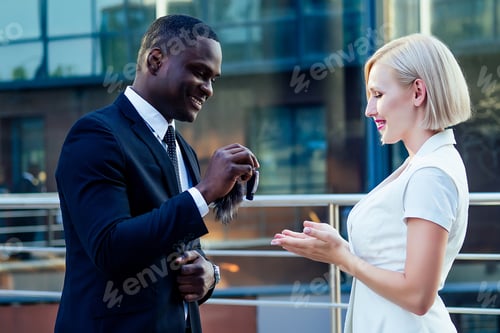 Preview: handsome Afro businessman in a stylish black suit gives car keys