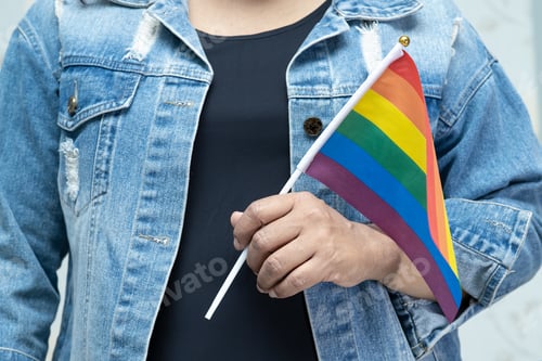 Preview: Asian lady wearing blue jean jacket or denim shirt and holding rainbow color flag, symbol