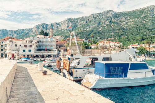 Preview: Coastal town of Drvenik with a moored boat and mountain backdrop under a clear sky