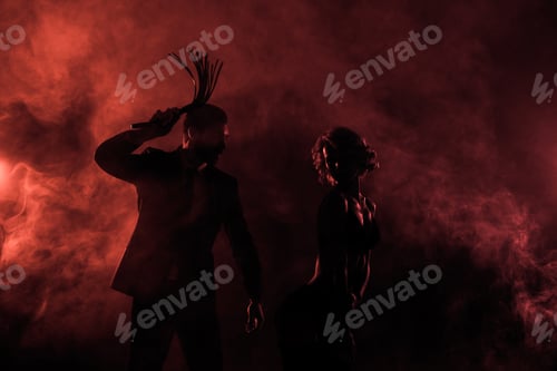 Preview: Man whipping seductive woman in lingerie on red smoke background