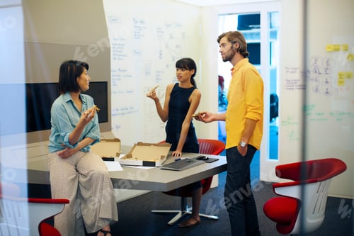 Preview: Business people in futuristic office having a meeting, eating pizza
