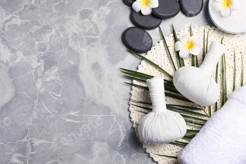 Preview: Spa bags, stones and orchid flowers on light gray marble table, flat lay. Space for text