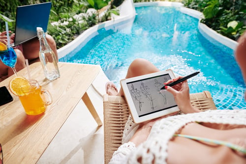 Preview: Designer working by swimming pool