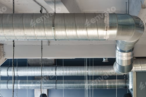Preview: Silver ventilation pipes hanging from the ceiling inside the building