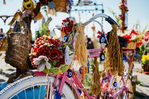 Preview: Bicycle in pink color with flowers stand in a beautiful touristic place.
