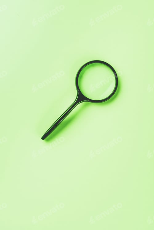 Preview: closeup shot of magnifying glass on green background