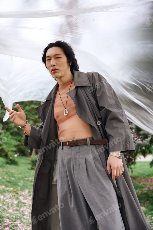 Preview: Stylish young man in grey outfit exudes confidence while exploring the park
