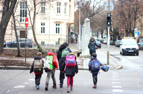 Preview: A woman help children to cross the street