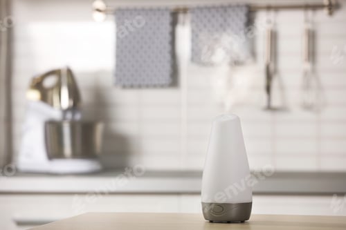 Preview: Modern essential oil diffuser on table indoors. Space for text