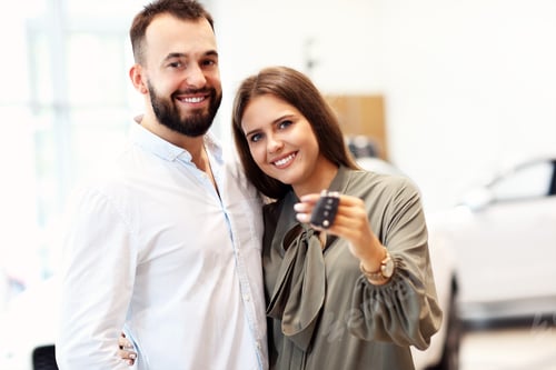 Preview: Adult couple choosing new car in showroom