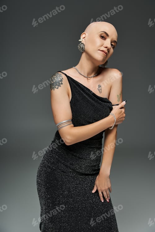 Preview: Elegant young woman with alopecia showcases her beauty in striking portrait against gray backdrop