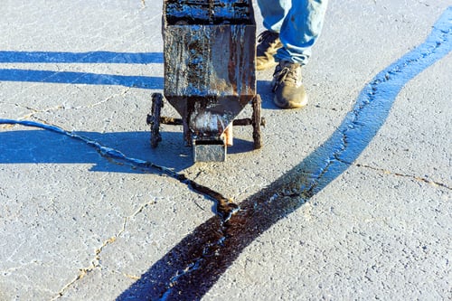 Preview: An asphalt patcher performs coated filling asphalt cracks sealing bitumen emulsion road