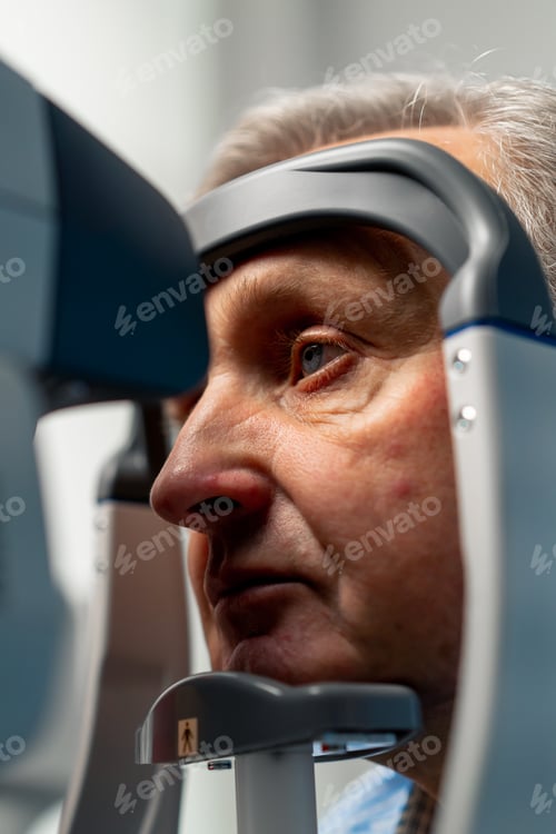 Preview: close-up in an ophthalmology clinic elderly patient is diagnosed with a vision test using a machine