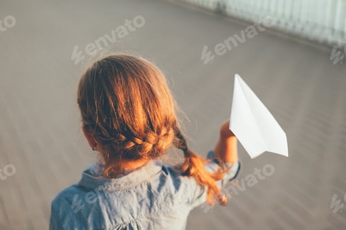 Preview: Girl playing with toy paper airplane