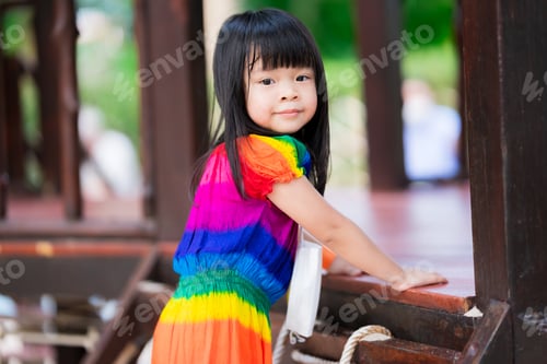 Preview: Closeup cute Asian girl is playing on net. Sweet smile child turns to look at camera.