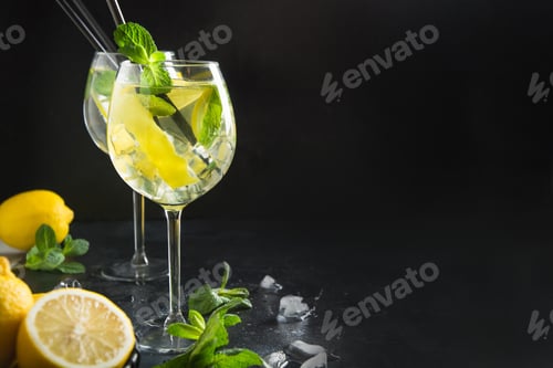 Vista previa: Cóctel de mojito o limonada con limón y menta en vasos. Bebida refrescante de verano.
