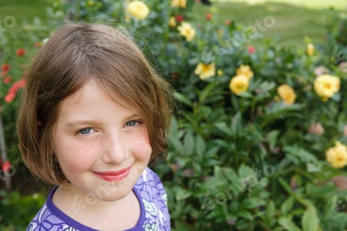Preview: A child in a garden looking up and smiling.