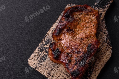 Preview: Delicious juicy beef steak on the bone, tomahawk with salt, spices and herbs