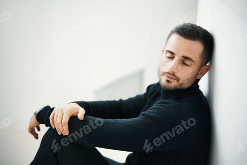 Preview: Tired man resting in minimalist space.