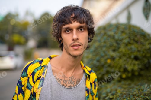 Preview: Face of young rebellious man on the sidewalk outdoors
