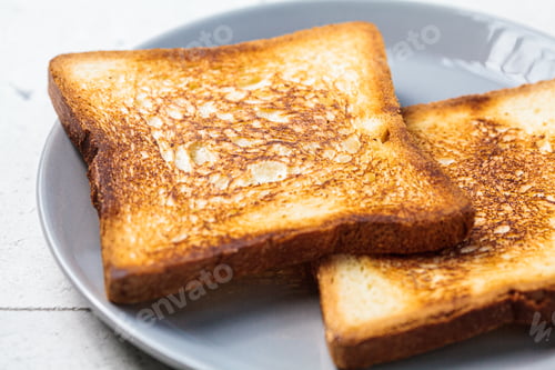 Preview: Toast with butter and apricot jam on gray plate. Breakfast food concept.