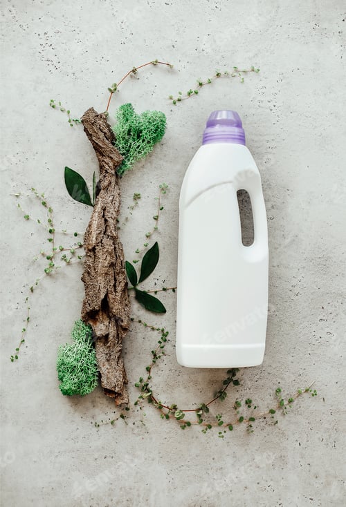 Preview: Composition with bottle of laundry detergent by tree bark, tiny mosses and grass