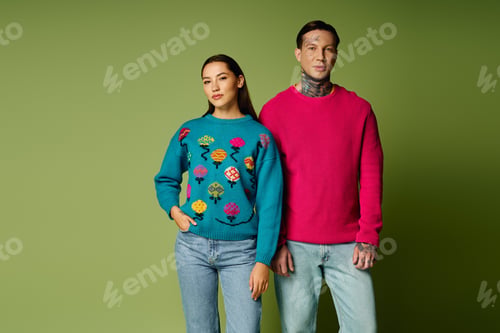 Preview: Young attractive individuals in colorful sweaters posing against a vibrant green backdrop