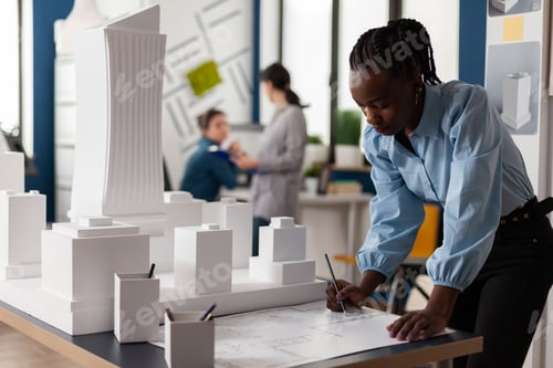 Preview: Residential architect drawing blueprints at desk in architectural office