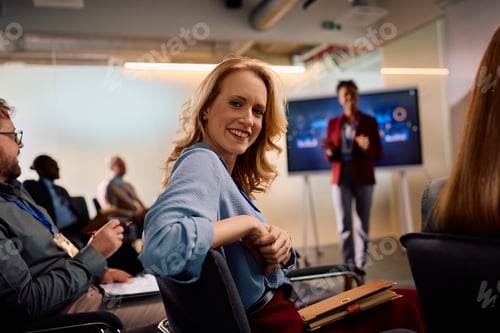 Preview: Happy businesswoman attending an education event in convention center and looking at camera.