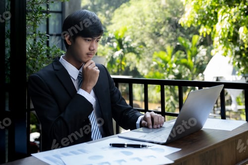 Preview: Young Man Working on Laptop in Outdoor Setting