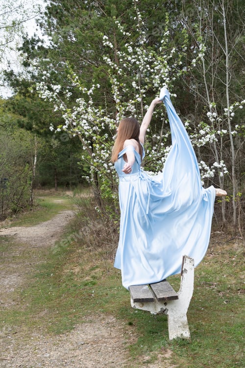 Preview: beautiful ballerina in a blue wedding dress on the background of a forest lake